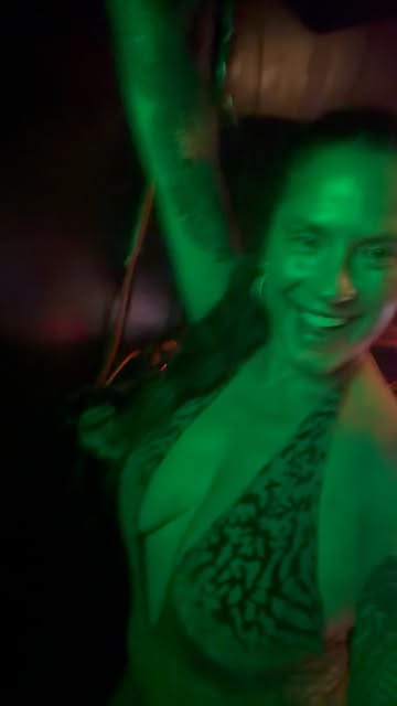 Mer on a green-lit dance floor